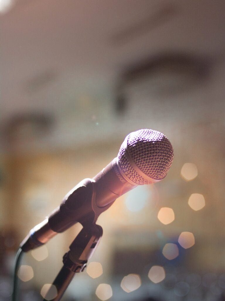 A microphone on a microphone stand with a bokeh background